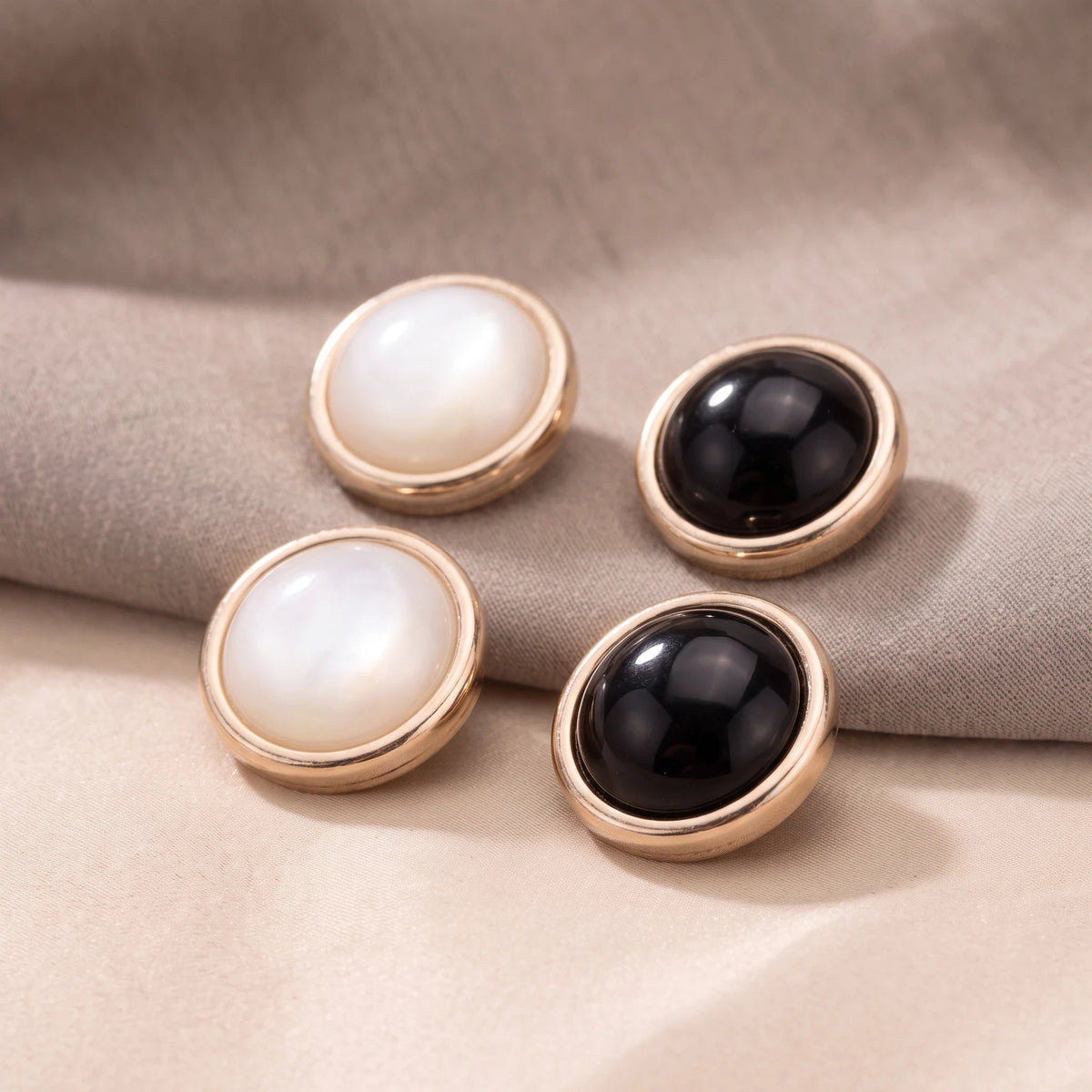 Eternal Aura Éclat hijab magnets in black and white with gold-toned round decorative frames on fabric