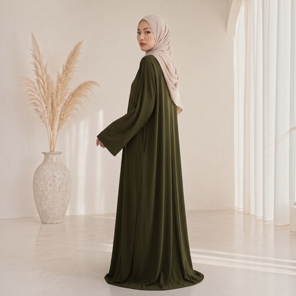 Eternal Aura The Serein Abaya in olivgrün mit weiten Ärmeln, getragen mit einem beigen Hijab in hellem Studio-Setting