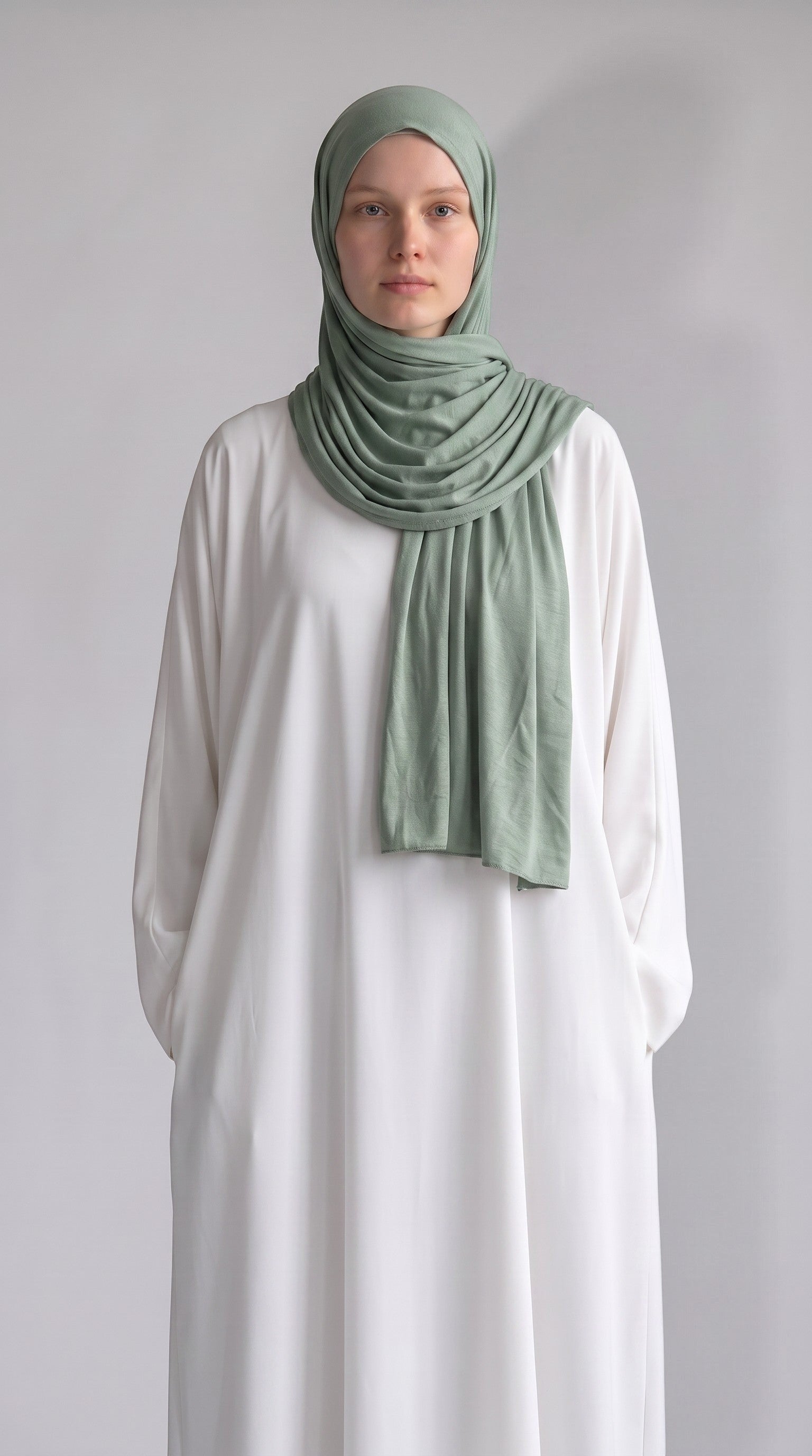 Eternal Aura sage green jersey hijab worn by a woman in a white dress, showcasing soft, stretchy fabric.